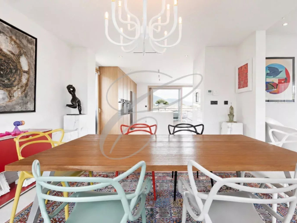 Interior of a modern villa with a large wooden table and colorful chairs, contemporary decor.
