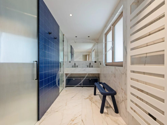 Modern bathroom with marble tiles and walk-in shower.