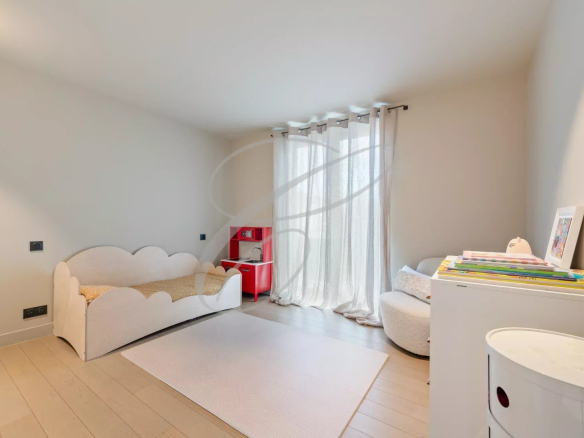 Room in a modern villa with a bed and a play area, natural light in Roquebrune-Cap-Martin.