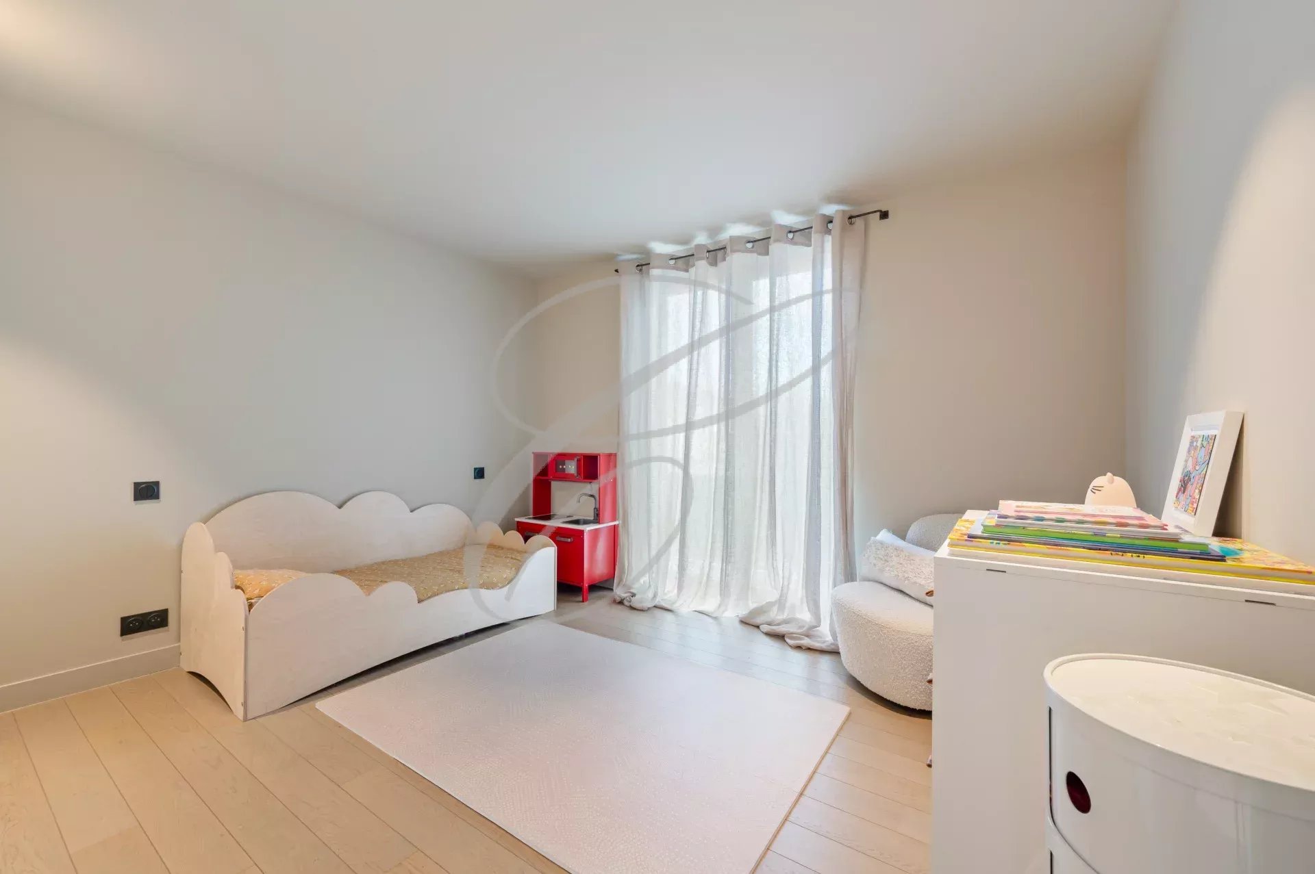Room in a modern villa with a bed and a play area, natural light in Roquebrune-Cap-Martin.