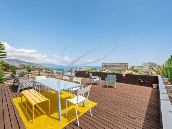 Wooden terrace with outdoor furniture and sea view in Roquebrune-Cap-Martin.