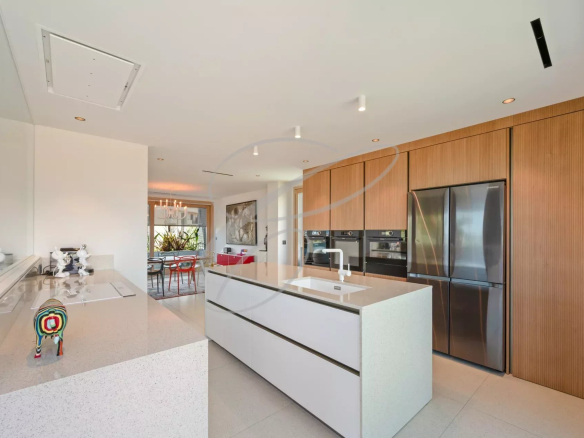 Modern and spacious kitchen in a villa in Roquebrune-Cap-Martin, with central island and high-end equipment.