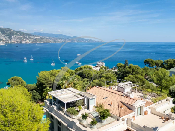 Vue panoramique sur la mer depuis un appartement en duplex à Roquebrune-Cap-Martin, entouré de verdure.