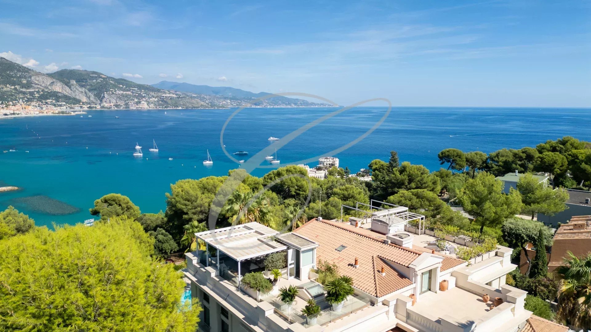 Vue panoramique sur la mer depuis un appartement en duplex à Roquebrune-Cap-Martin, entouré de verdure.
