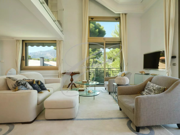 Intérieur d'un appartement de luxe à Roquebrune-Cap-Martin, salon lumineux avec canapé et vue sur la nature.