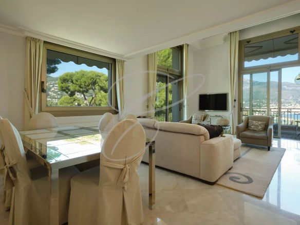 Intérieur d'un appartement de luxe avec salon, salle à manger et vue sur la mer.
