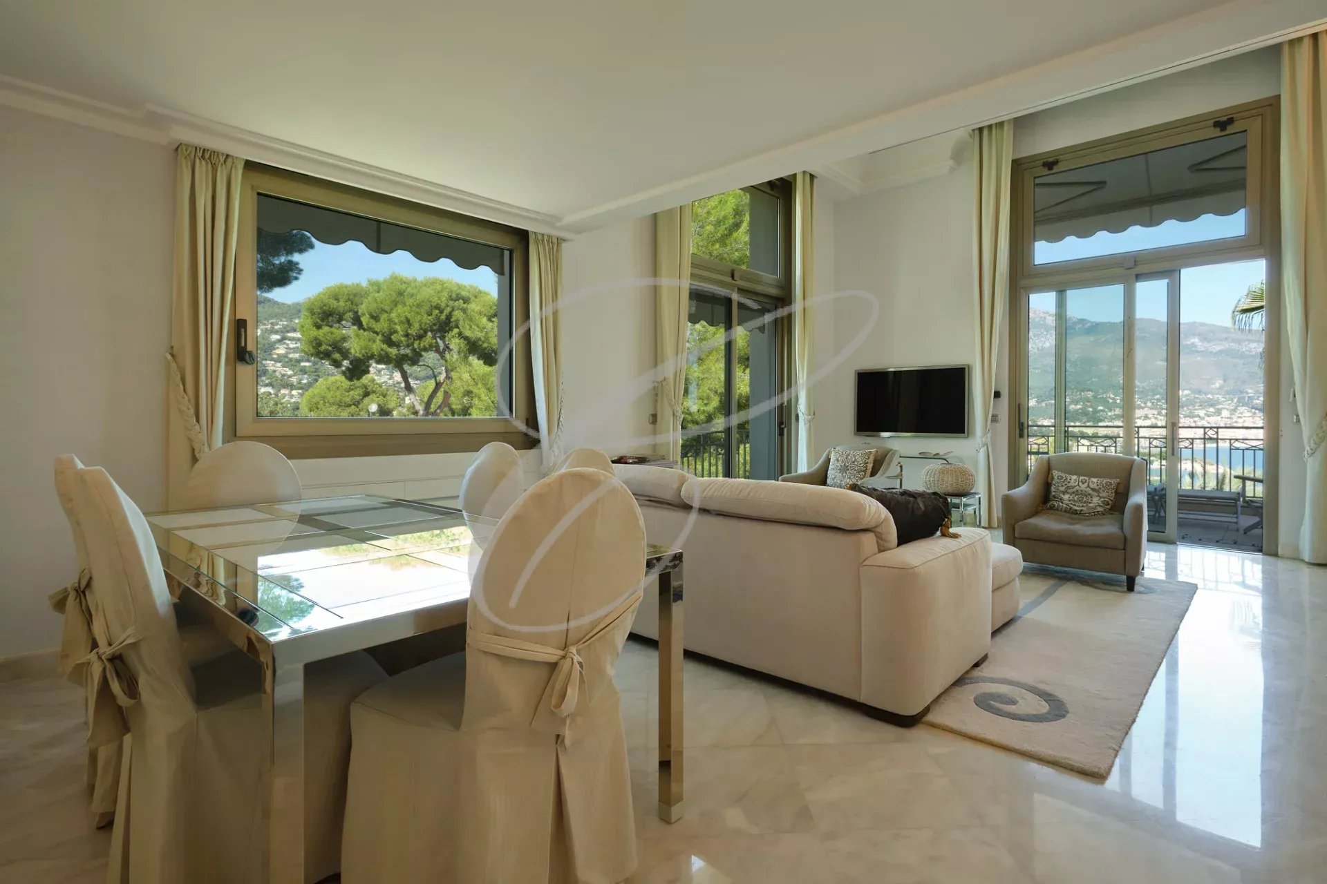 Intérieur d'un appartement de luxe avec salon, salle à manger et vue sur la mer.