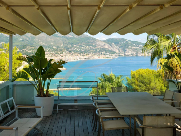Vue depuis une terrasse avec mobilier extérieur et mer en arrière-plan à Roquebrune-Cap-Martin.