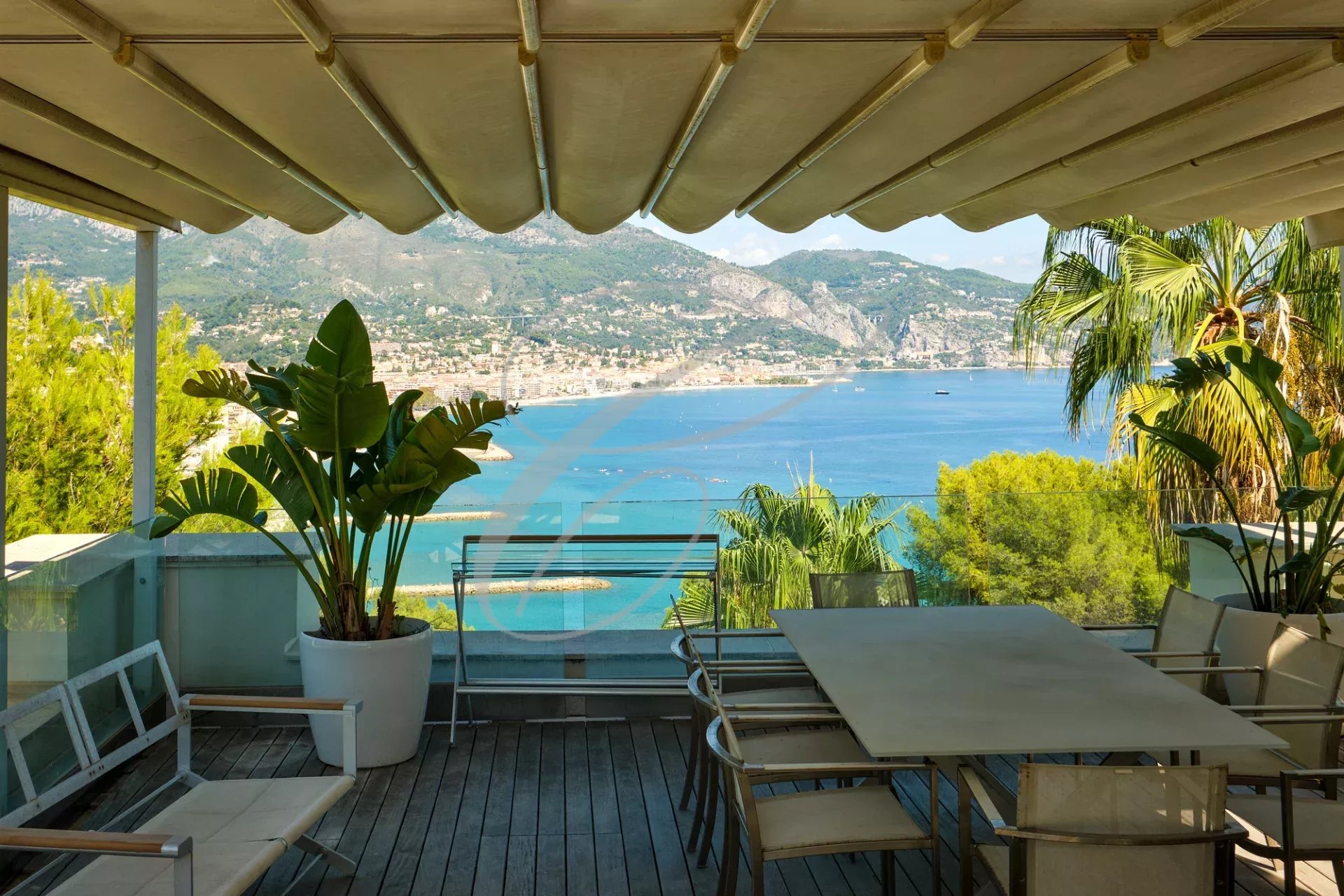 Vue depuis une terrasse avec mobilier extérieur et mer en arrière-plan à Roquebrune-Cap-Martin.
