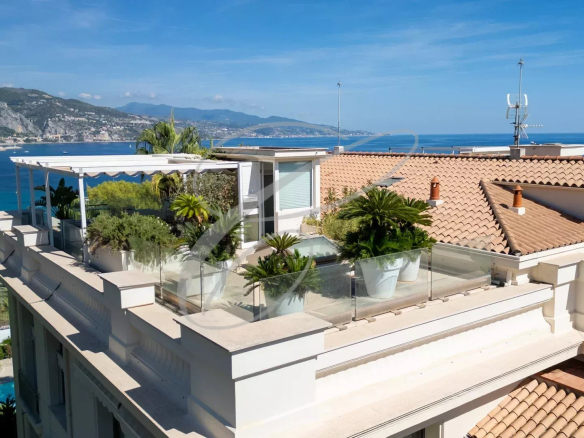 Vue du toit-terrasse d'un appartement à Roquebrune-Cap-Martin avec plantes et vue sur la mer.