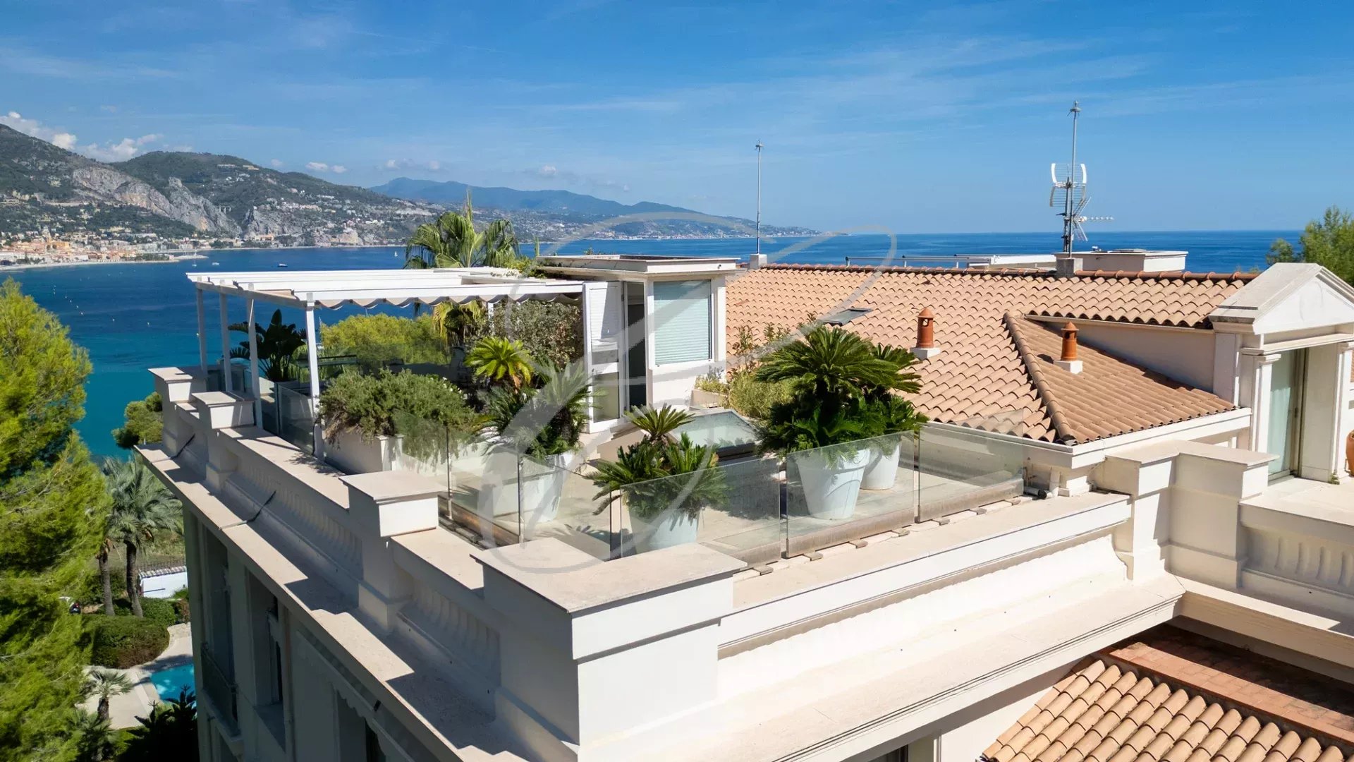 Vue du toit-terrasse d'un appartement à Roquebrune-Cap-Martin avec plantes et vue sur la mer.