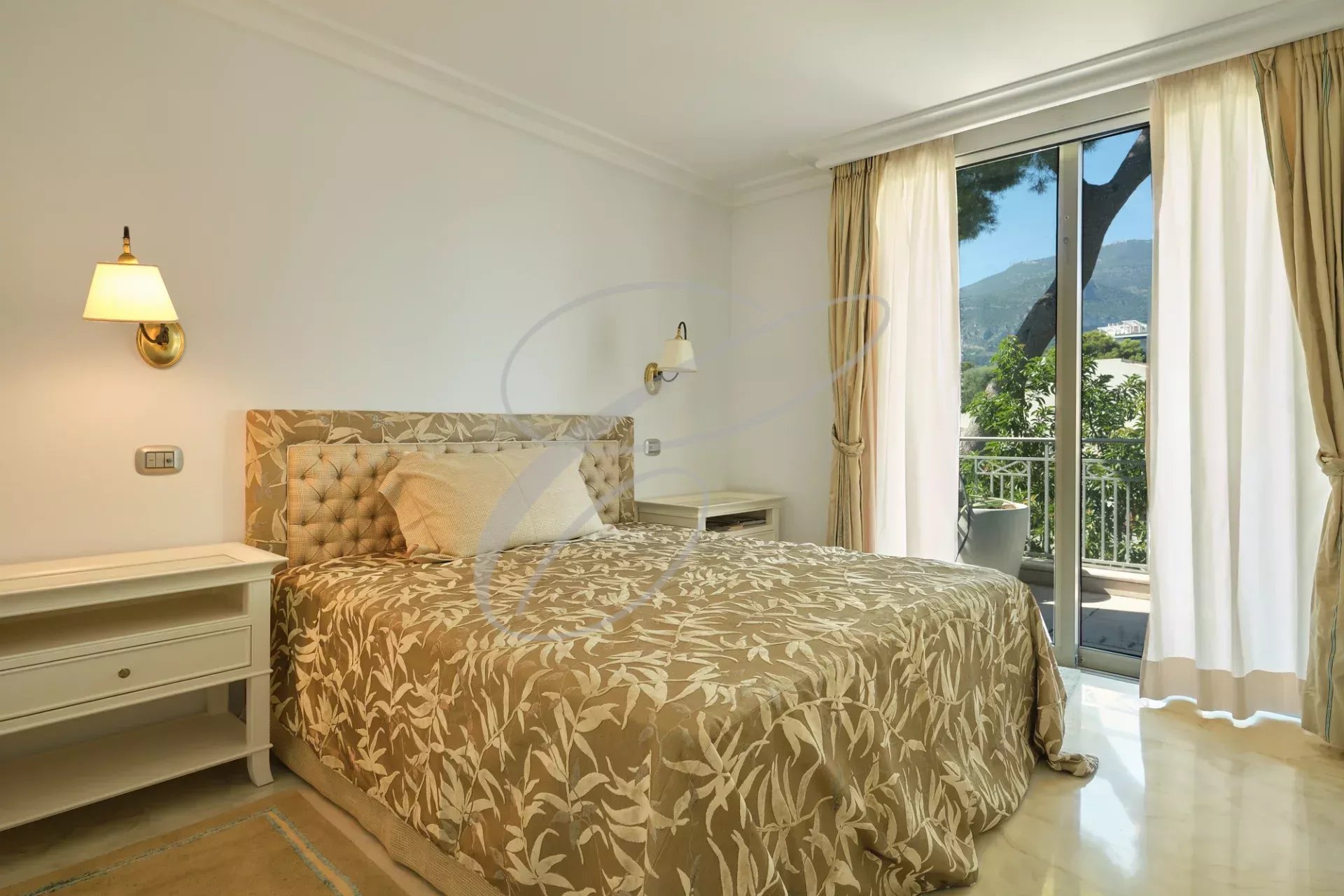 Chambre d'un appartement de luxe à Roquebrune-Cap-Martin avec lit et balcon.