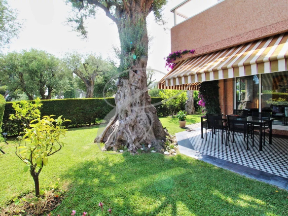 Terrasse avec mobilier de jardin et jardin verdoyant dans une résidence à Roquebrune-Cap-Martin.