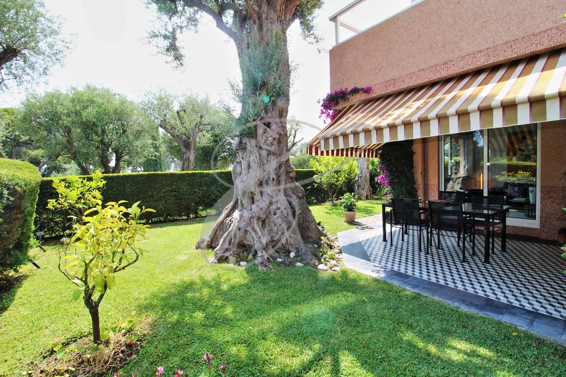 Terrasse et jardin à Roquebrune-Cap-Martin Terrasse avec mobilier de jardin et jardin verdoyant dans une résidence à Roquebrune-Cap-Martin.