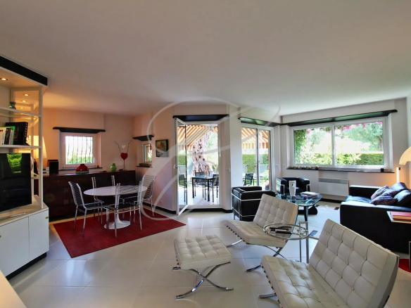 Intérieur d'un appartement de luxe avec salon, cuisine américaine et accès au jardin.
