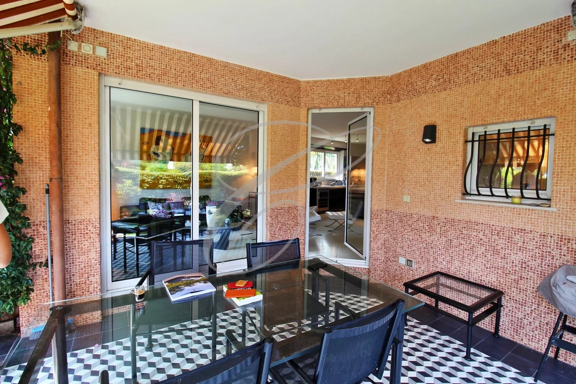 Terrasse d’appartement à Roquebrune-Cap-Martin Terrasse d'un appartement avec mobilier de jardin, vue sur un espace vert.