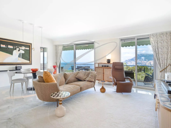 Intérieur d'un appartement spacieux avec vue sur la mer et Monaco, salon lumineux et moderne.