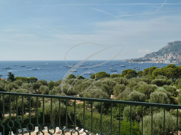 Vue panoramique sur la mer et Monaco depuis une terrasse avec des bateaux sur l'eau.