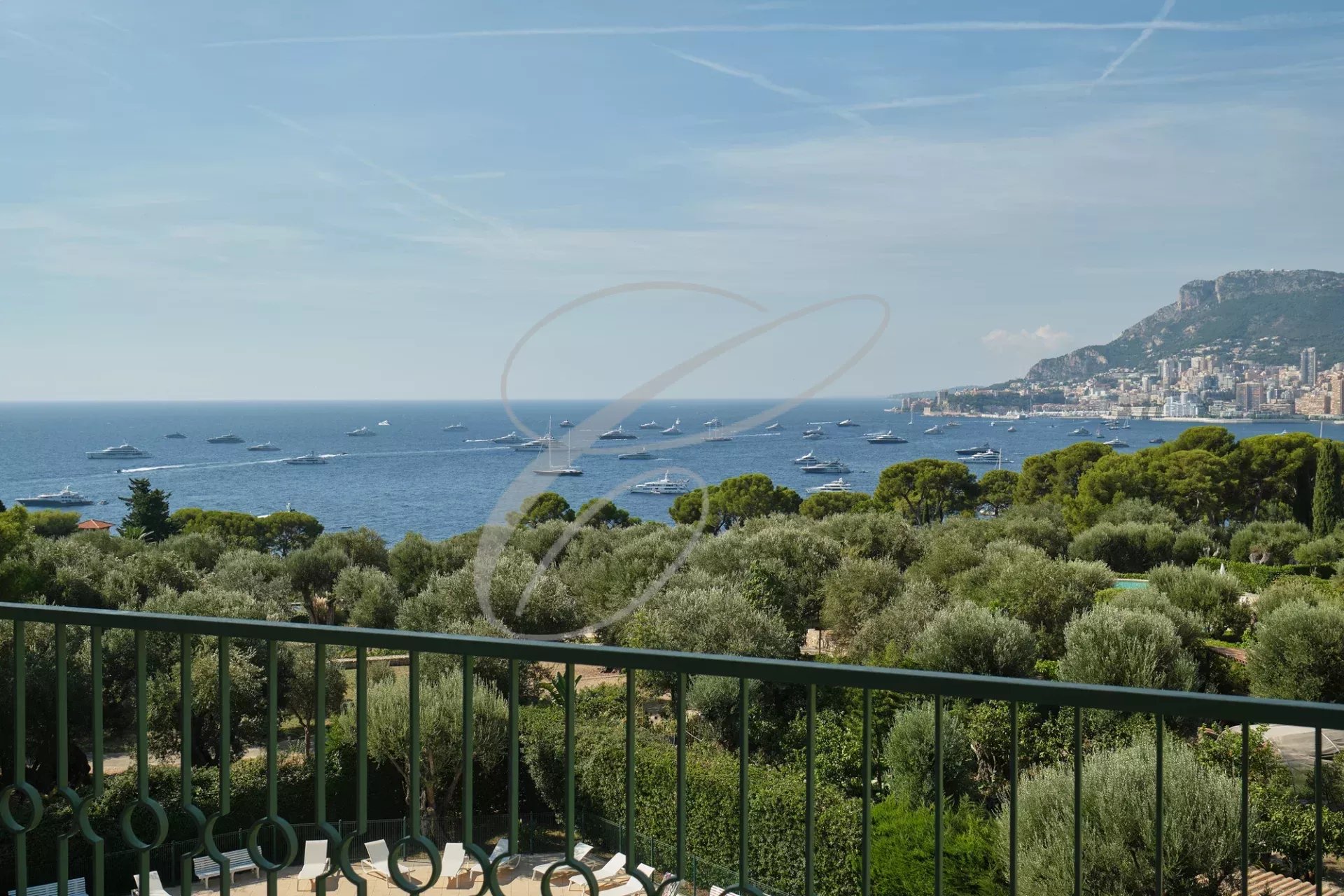 Vue panoramique sur la mer et Monaco depuis une terrasse avec des bateaux sur l'eau.