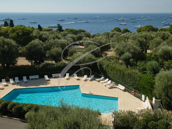 Vue de la piscine d'une résidence avec vue sur la mer et des bateaux au large à Roquebrune-Cap-Martin.