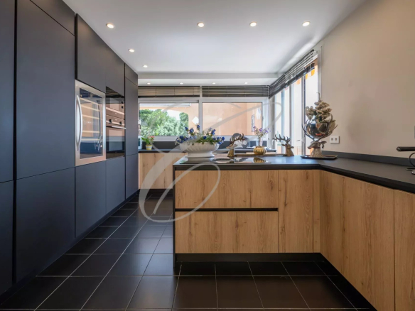 Modern kitchen with wood and black furniture, natural lighting, garden view.