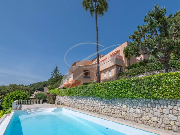 Exterior view of an apartment-villa with swimming pool in Roquebrune-Cap-Martin, garden and sea in the background.