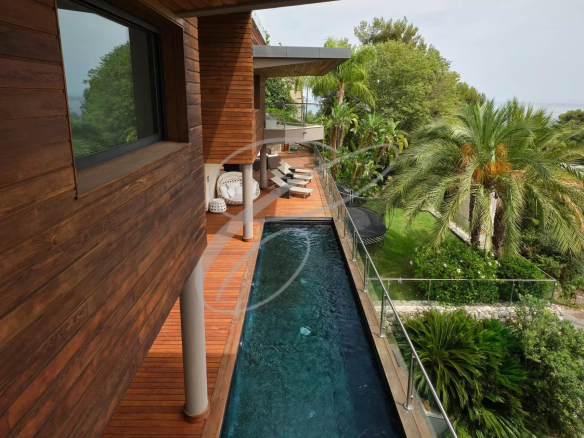 Vue extérieure d'une villa contemporaine avec piscine et jardin à Roquebrune-Cap-Martin.