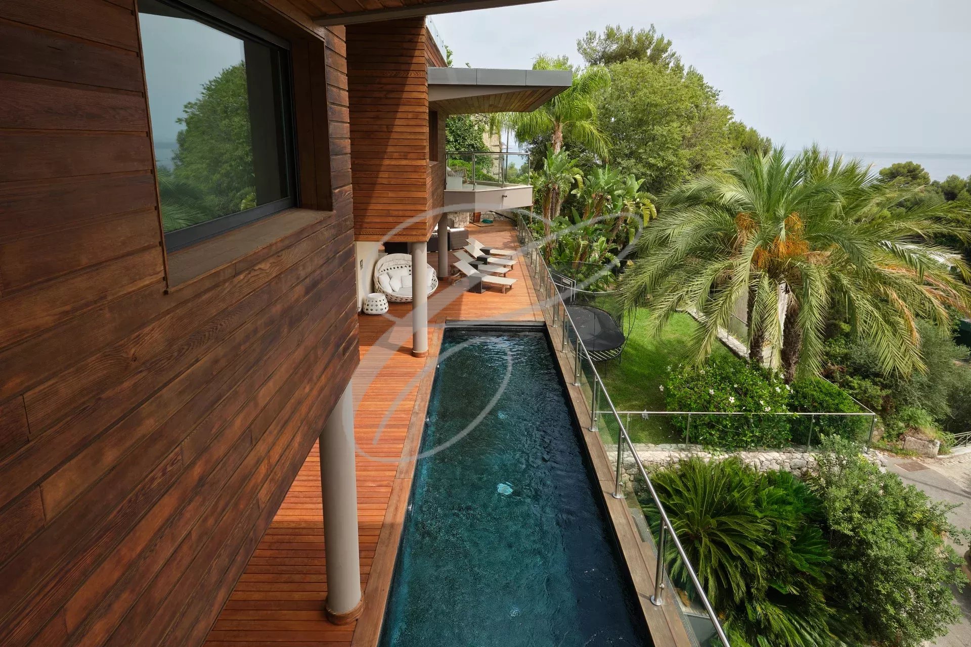 Vue extérieure d'une villa contemporaine avec piscine et jardin à Roquebrune-Cap-Martin.