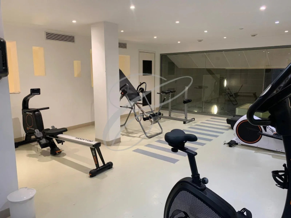 Salle de sport dans une résidence avec équipements de fitness.