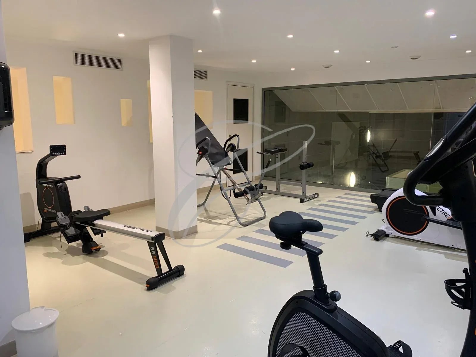 Salle de sport dans une résidence avec équipements de fitness.