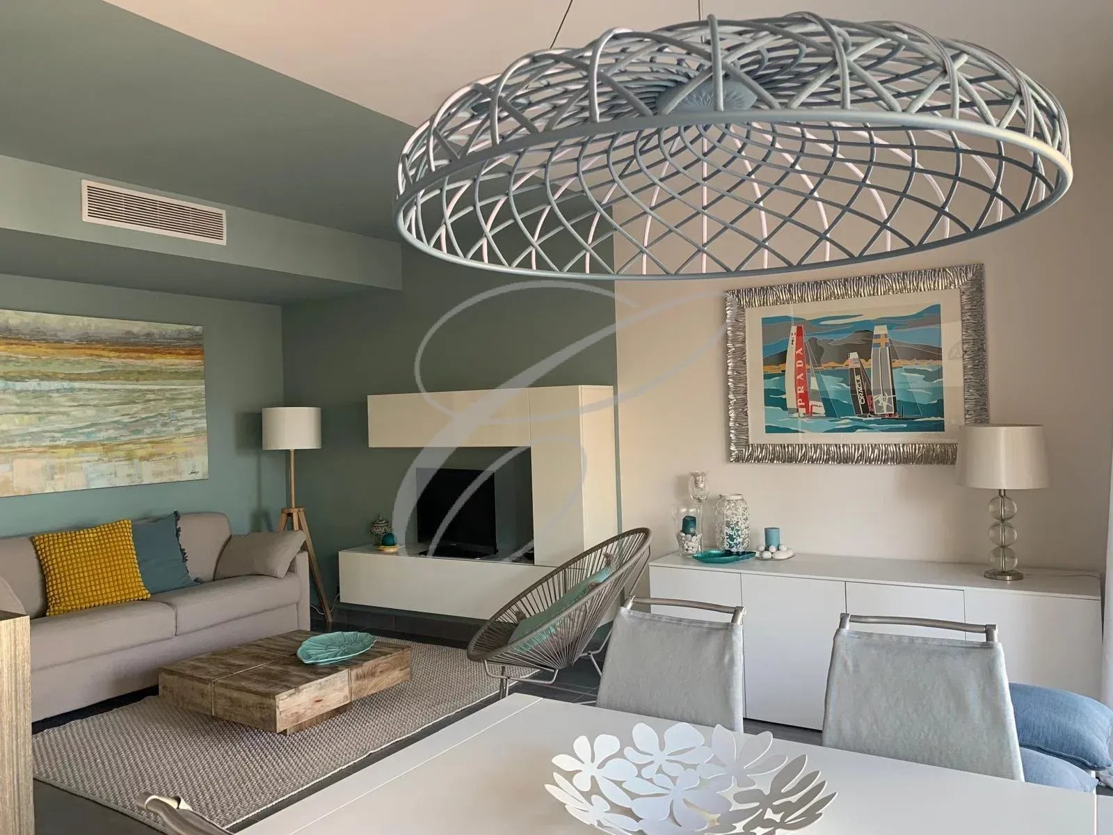 Intérieur d'un appartement moderne avec salon, table à manger et décoration contemporaine.