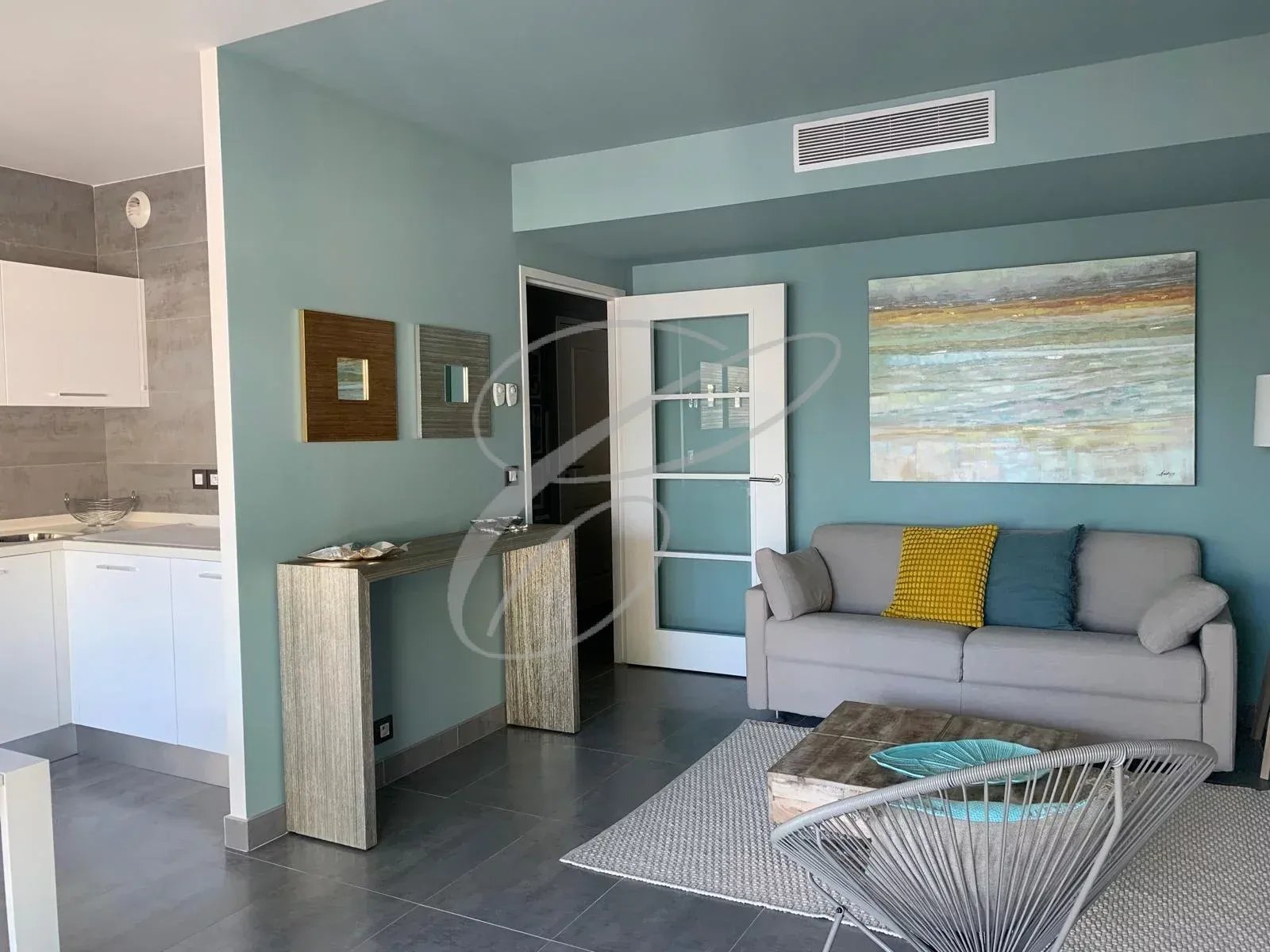 Intérieur d'un appartement moderne avec salon, cuisine équipée et décoration contemporaine à Menton.