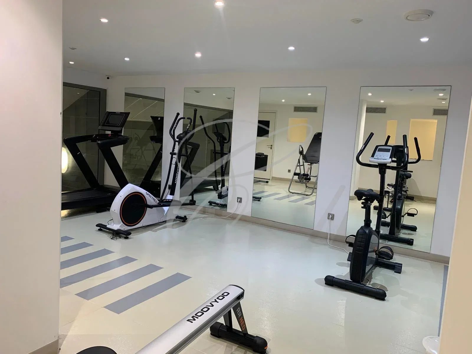 Salle de sport dans une résidence de standing à Menton, équipée de divers appareils de fitness.