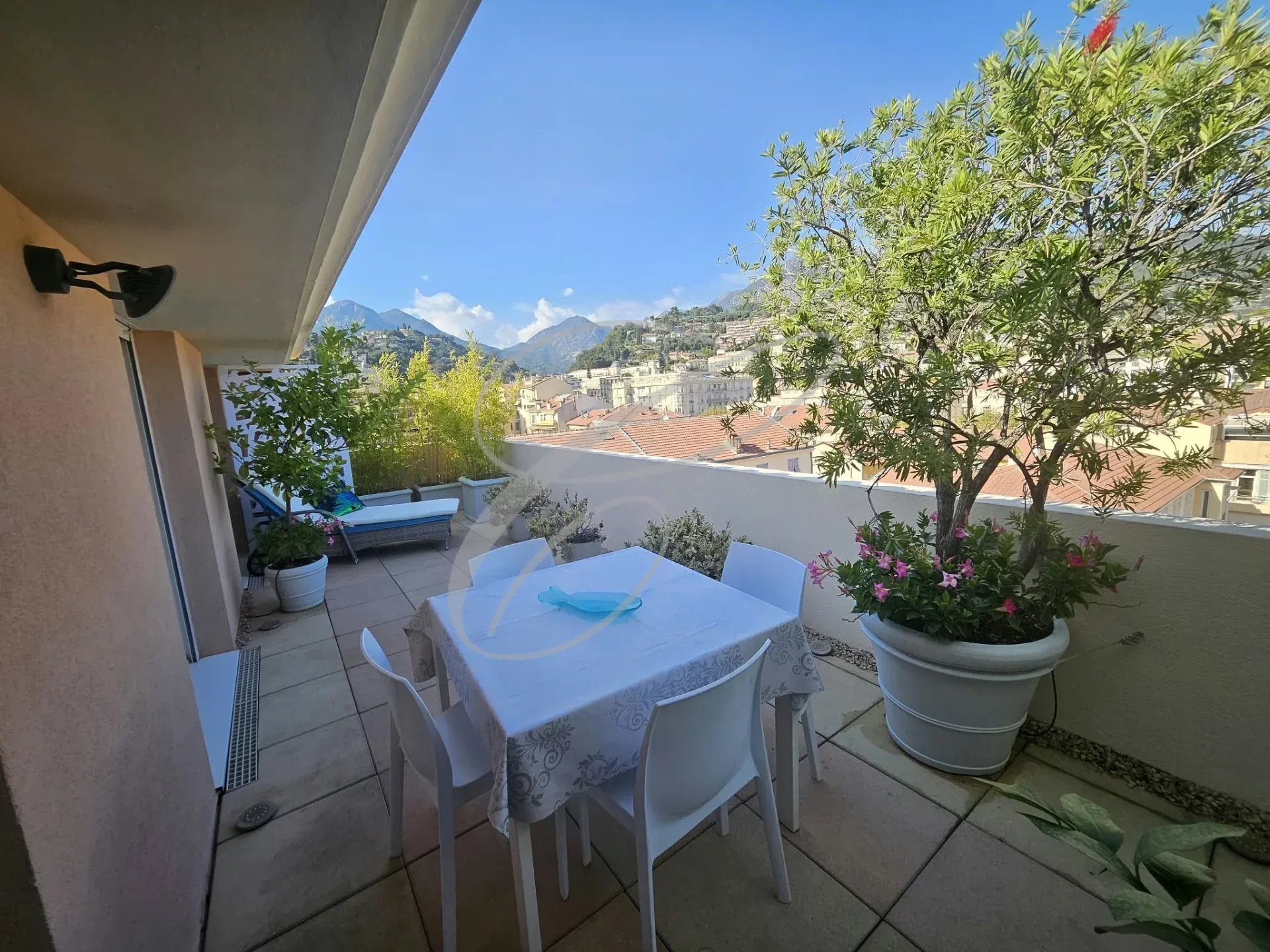 Terrasse d'un appartement rénové à Menton avec vue sur la ville et la mer.