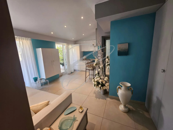 Intérieur d'un appartement rénové avec salon, cuisine ouverte et décoration moderne à Menton.