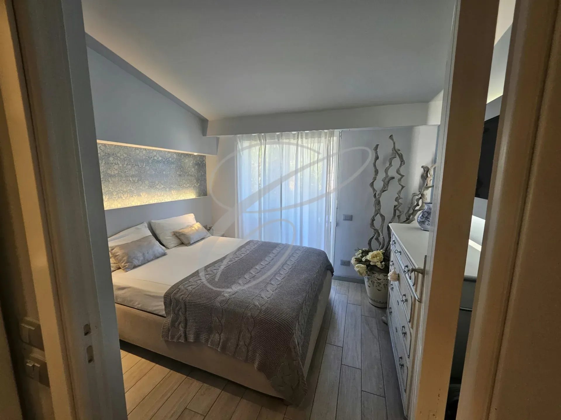 Chambre d'un appartement rénové avec lit double et décoration moderne.