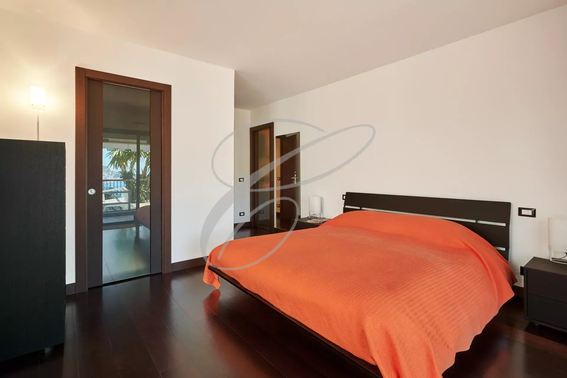 Chambre d’appartement à Roquebrune-Cap-Martin Chambre avec lit double et accès à une terrasse, décor moderne à Roquebrune-Cap-Martin.