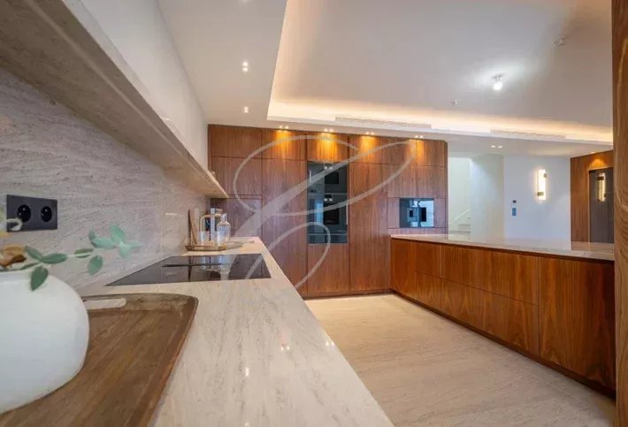 Cuisine d’une villa à Nice Cuisine moderne avec des meubles en bois et un plan de travail en marbre dans une villa à Nice.