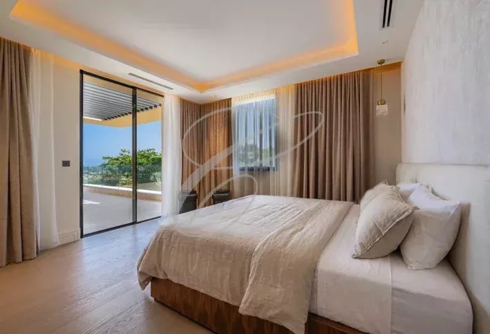 Chambre de luxe dans une villa à Nice Chambre lumineuse avec lit double et accès à une terrasse, vue sur la nature.