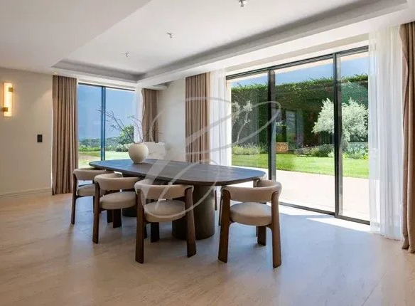 Intérieur d'une villa à Nice avec une salle à manger lumineuse et vue sur le jardin.