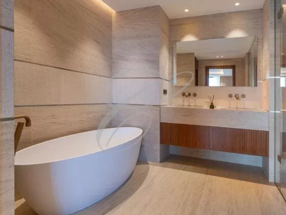 Salle de bain moderne avec baignoire et meuble en bois.