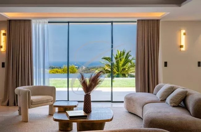Intérieur d’une villa à Nice Intérieur d'une villa luxueuse à Nice avec vue sur la mer et montagnes, salon moderne et lumineux.