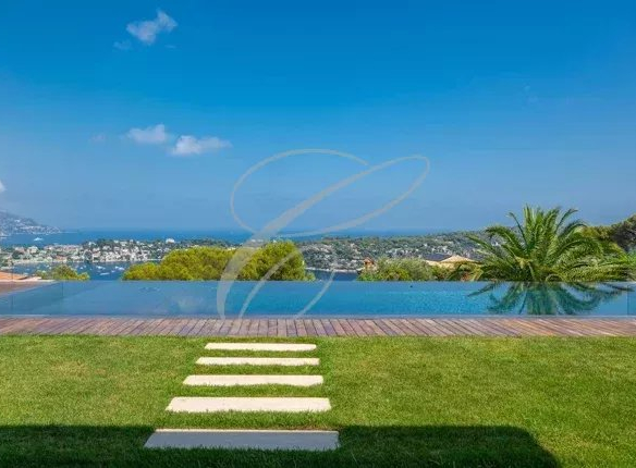 Vue d'une villa de luxe avec piscine à Nice, entourée d'un jardin paysager et vue sur la mer.