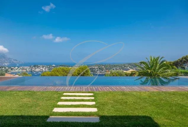 Villa de luxe à Nice Vue d'une villa de luxe avec piscine à Nice, entourée d'un jardin paysager et vue sur la mer.