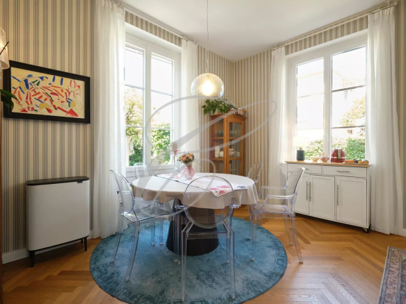 Intérieur d'une villa à Roquebrune-Cap-Martin avec une salle à manger lumineuse et des fenêtres donnant sur le jardin.