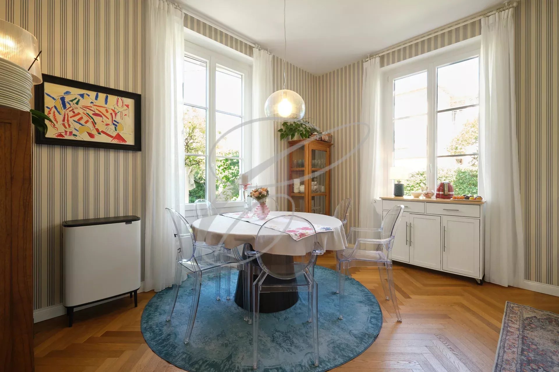 Salle à manger de la villa à Roquebrune-Cap-Martin Intérieur d'une villa à Roquebrune-Cap-Martin avec une salle à manger lumineuse et des fenêtres donnant sur le jardin.