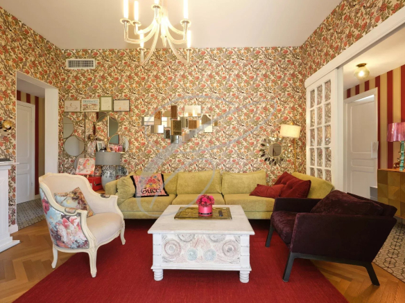 Intérieur d'une villa à Roquebrune-Cap-Martin avec un salon décoré de motifs floraux et un mobilier coloré.