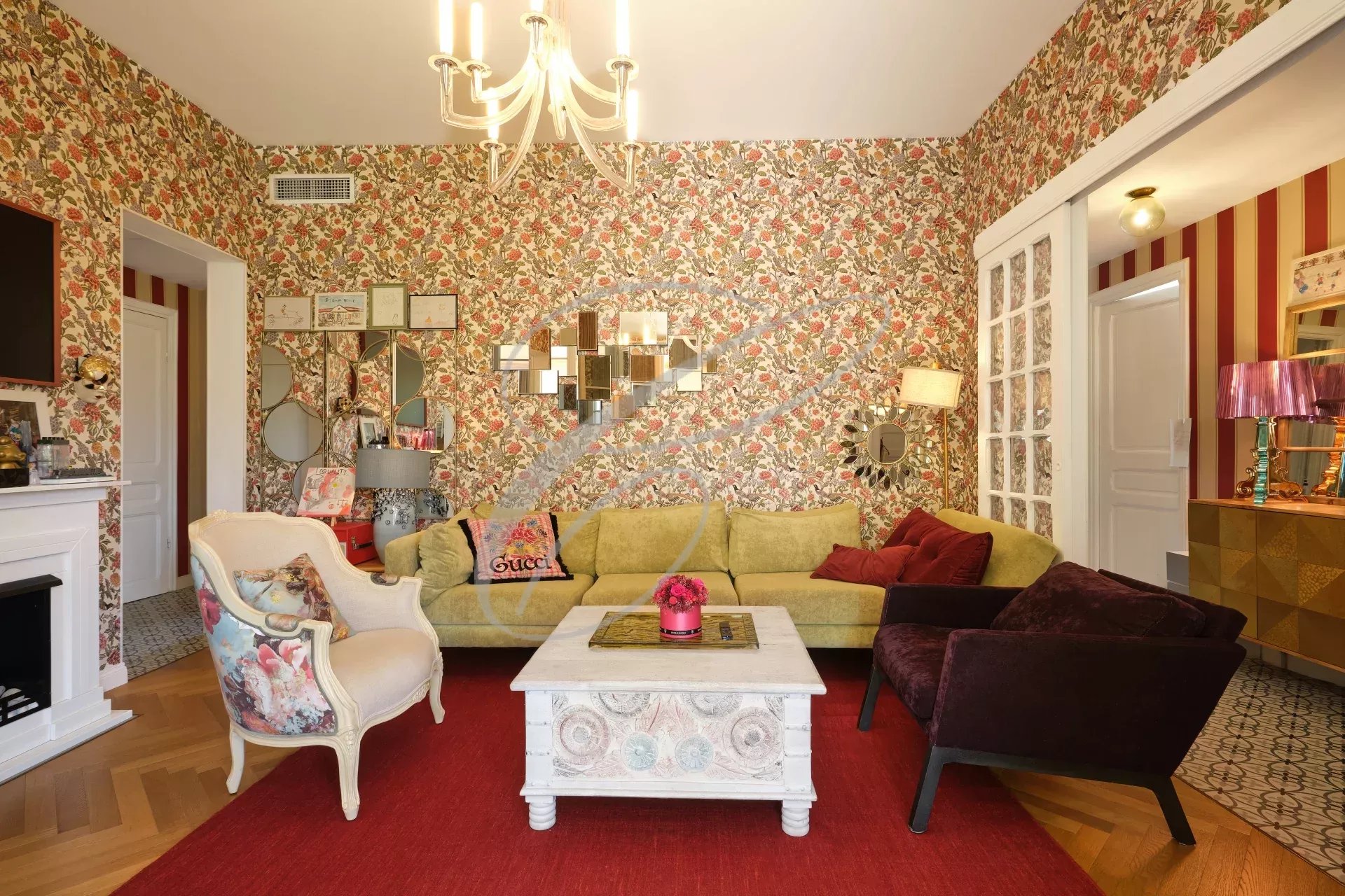 Intérieur de villa à Roquebrune-Cap-Martin Intérieur d'une villa à Roquebrune-Cap-Martin avec un salon décoré de motifs floraux et un mobilier coloré.