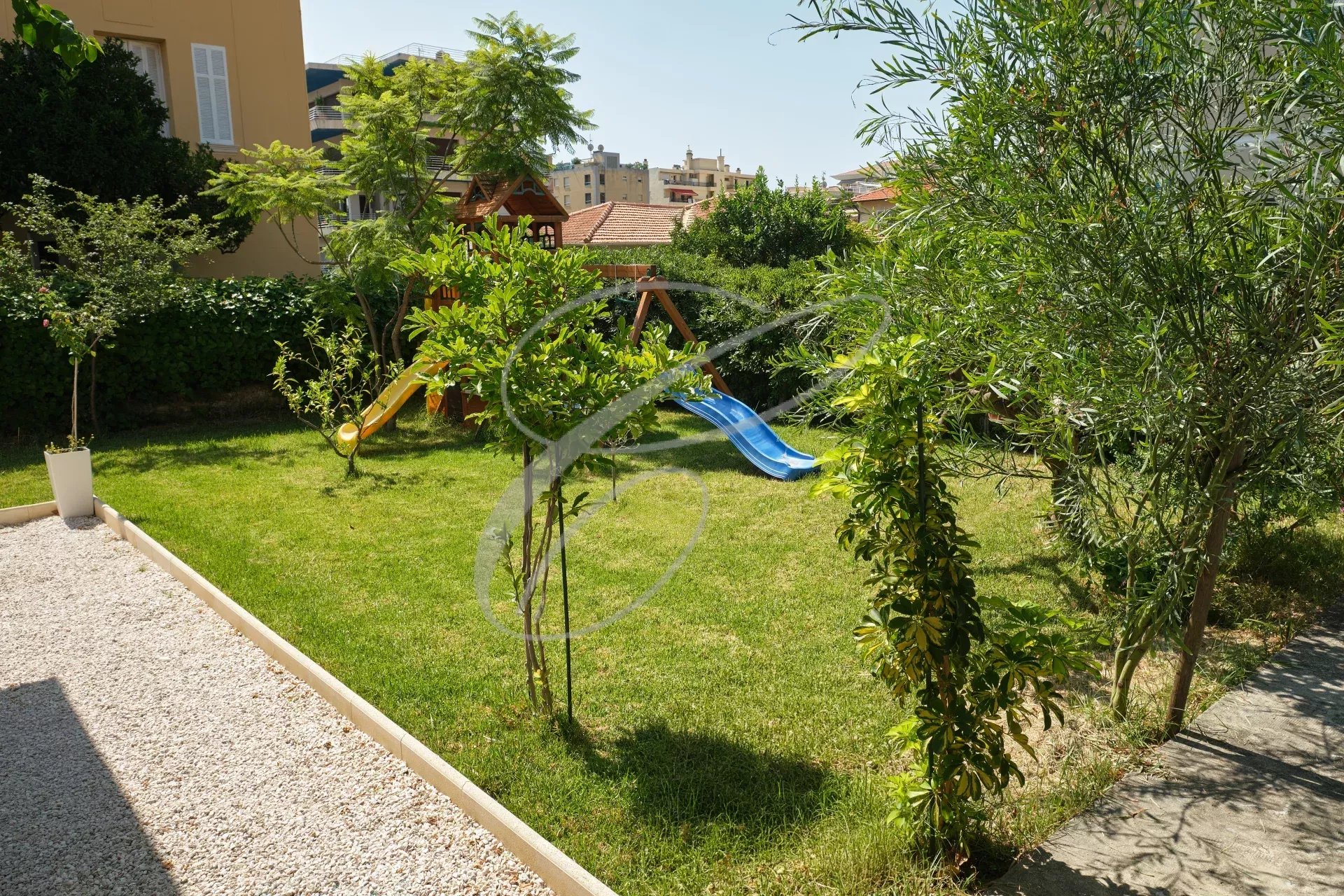 Jardin de villa à Roquebrune-Cap-Martin Jardin ensoleillé avec toboggans et espace vert à Roquebrune-Cap-Martin.
