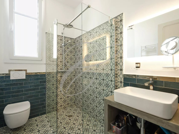 Salle de bain moderne avec douche à l'italienne et carrelage décoratif.